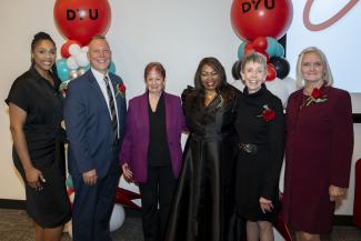 Alumni stand for a photo at an awards ceremony