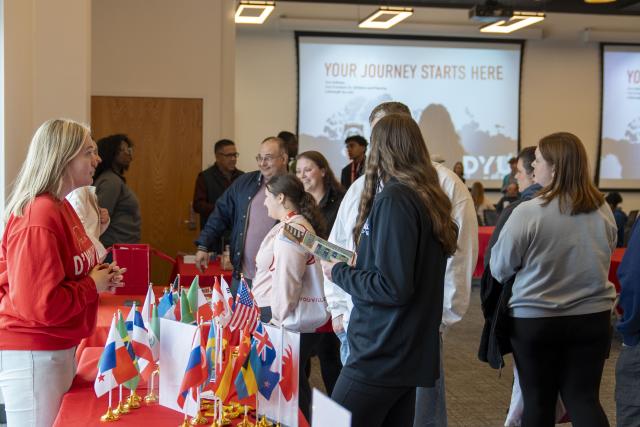 People sharing information over a table at an open house event