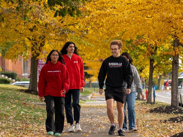 Students walking under yellow fall leaves
